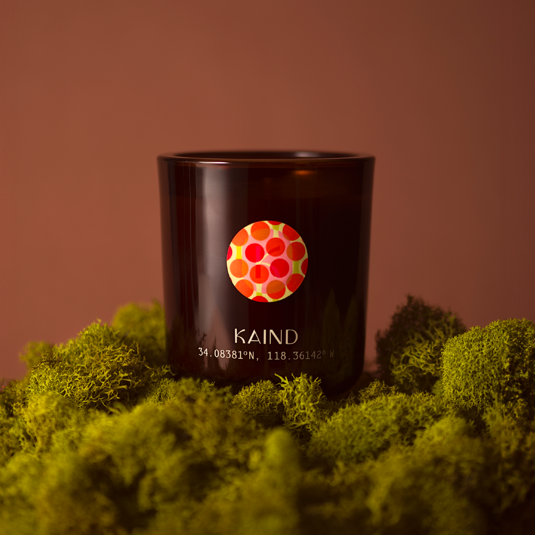 image of a candle in a brown background sitting over green moss a brown background